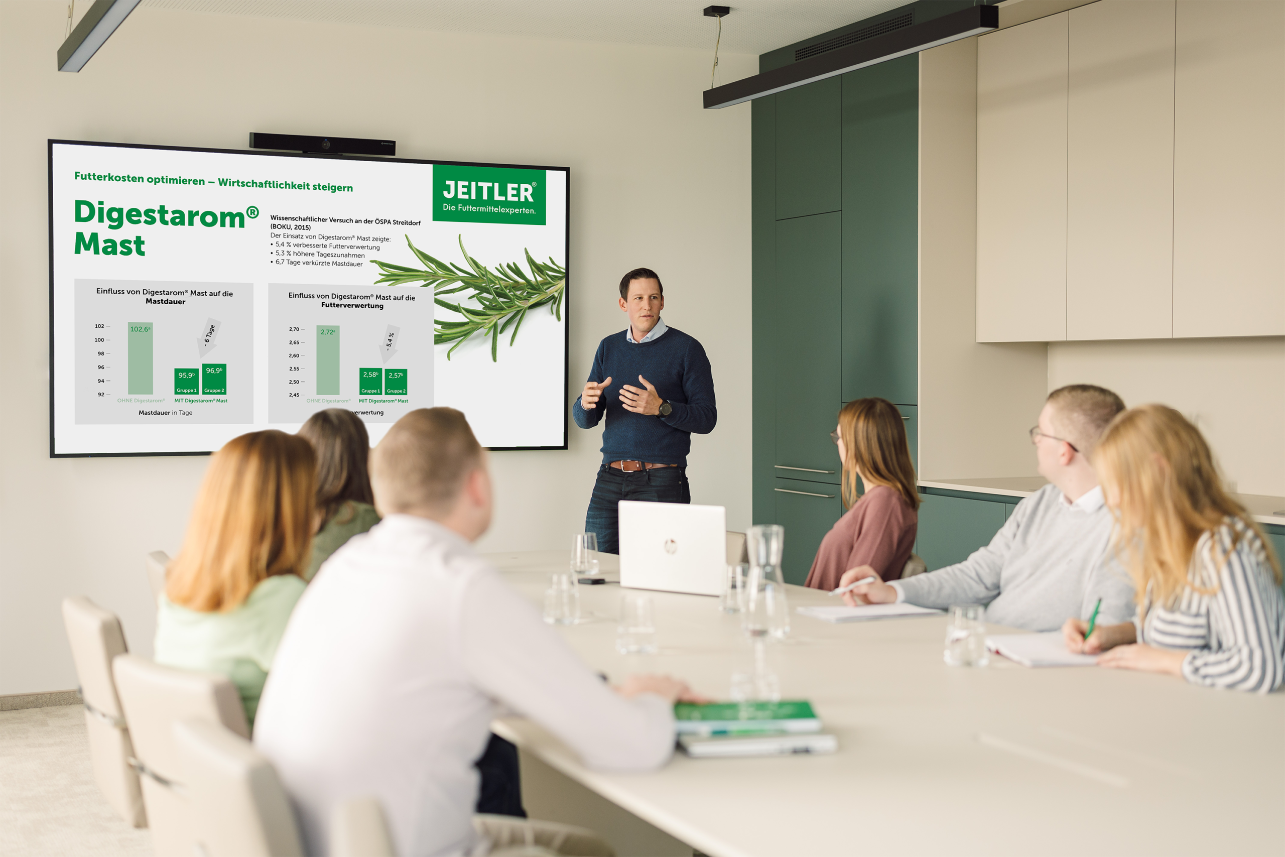 Ein Mann hält eine Präsentation vor Kolleginnen und Kollegen in einem Besprechungsraum